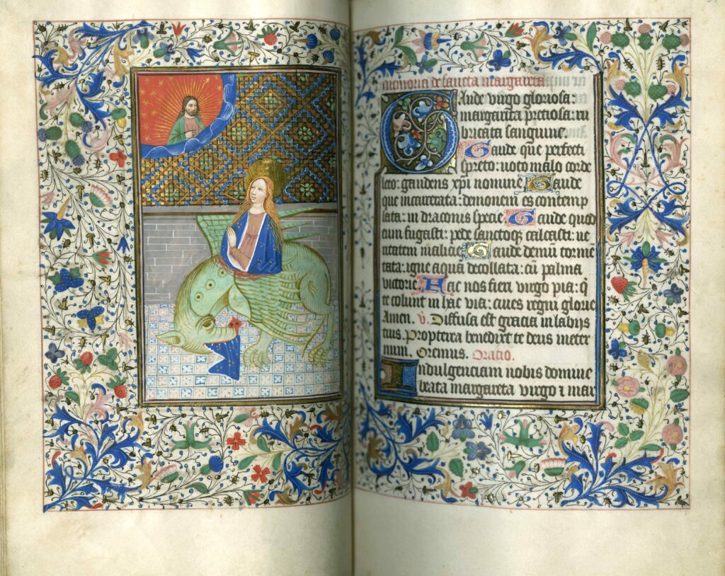 A highly decorated two-page medieval manuscript spread. On the left-hand side is an image of a woman with a halo protruding from the stomach of a dragon. The edge of her dress sticks out of the dragon's mouth. The woman is praying to Christ, who appears above her.