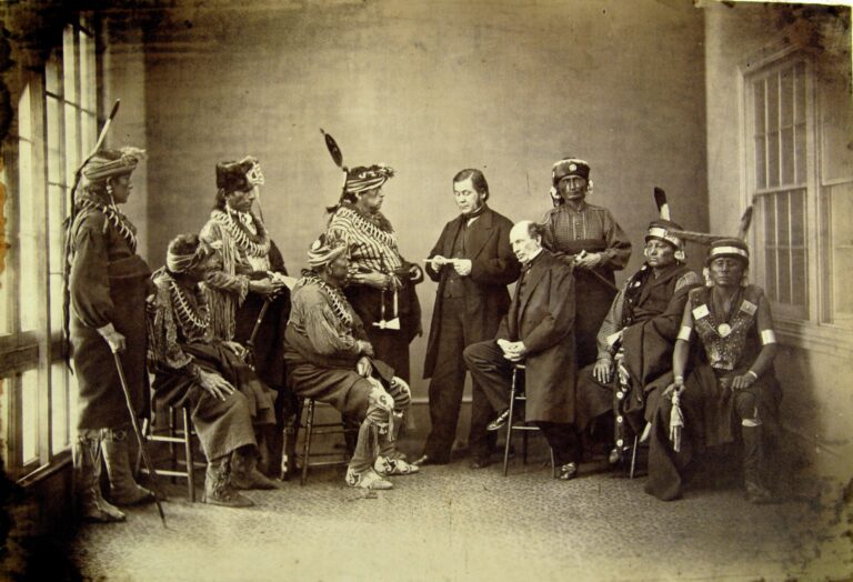 Black-and-white photograph of a group of Indigenous leaders. Some wear traditional dress and some where Euro-American suits.
