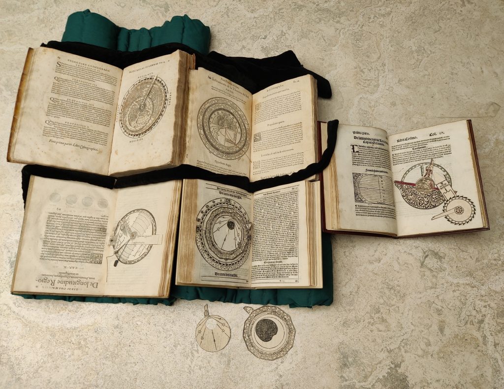 Spread of five printed books, each open to a page with a rotatable dial or stack of dials. These dials are very detailed and clearly for scientific calculations.