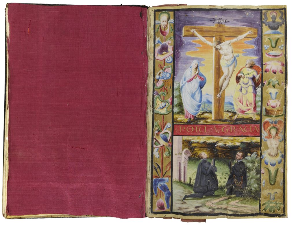 Two-page spread of an open book. On the right-hand page is an illumination of two white men kneeling in a garden. They look up to the image above them, which shows Jesus being crucified. On the left-hand side of the cross is a woman wearing a blue robe. On the right is figure wearing colorful robes and a red cape. All three figures are white. The page on the left is fully covered by a square of red silk.