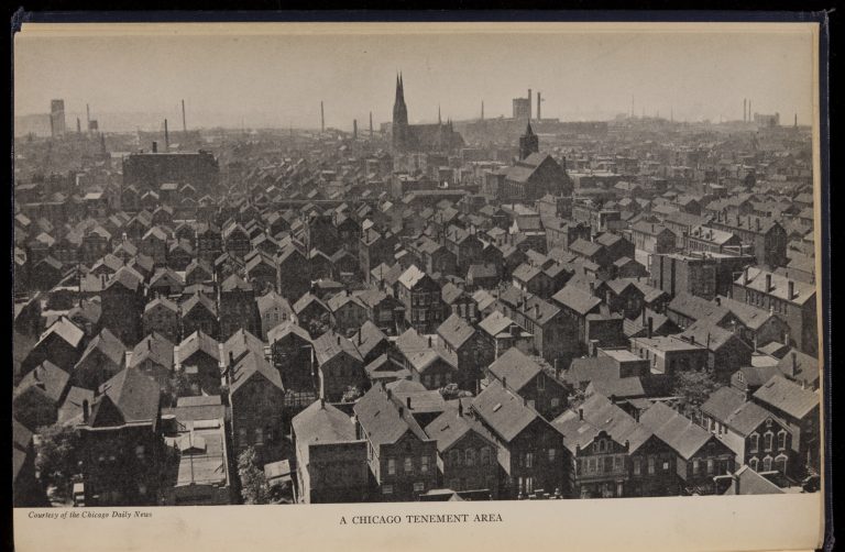 Elevated view of a city neighborhood showing rows of tightly packed two-and-three story houses with a church and many industrial smoke stacks on the horizon.