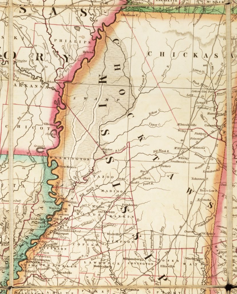 Detail of a map. The map has been dissected: cut into squares and glued to a piece of fabric. Four dissection lines are visible near the edges of this image.