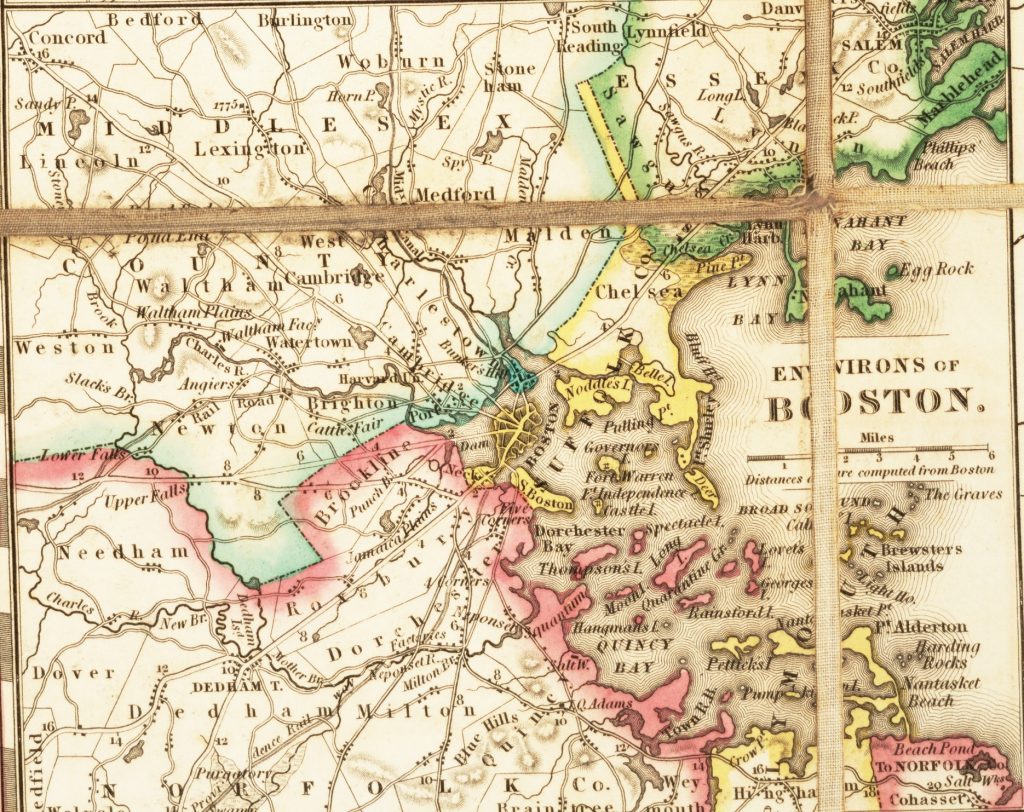 Detail of a map showing Boston, MA, and its surroundings. Dissection folds make a cross in the upper right of the image.