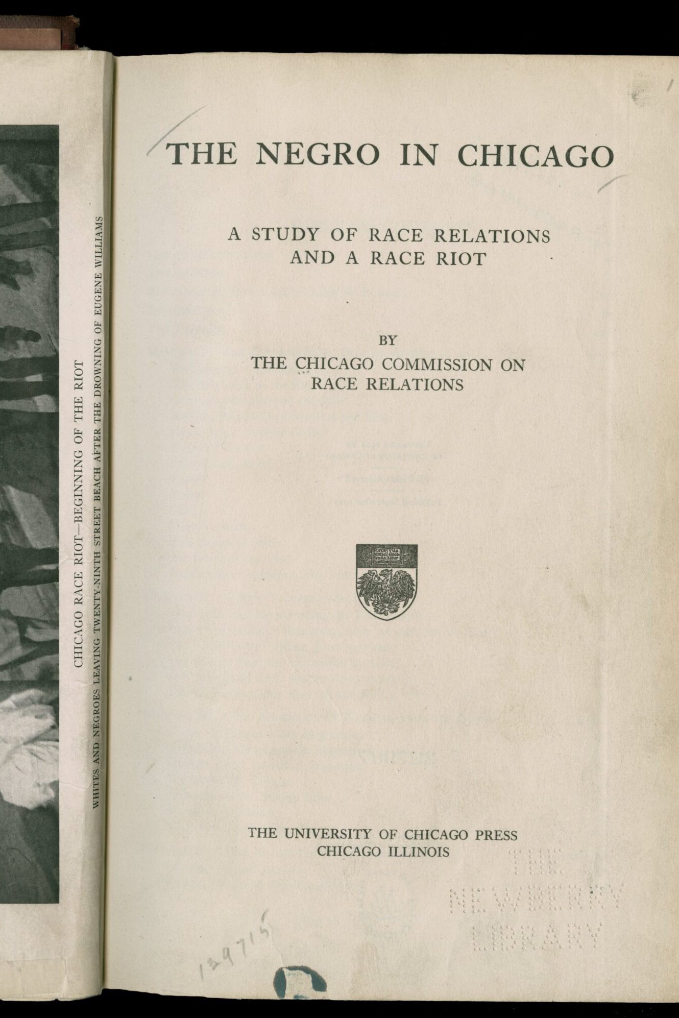 Double page spread of a printed book. On the right is the title page for The Negro in Chicago by the Chicago Commission of Race Relations. On the left is a black-and-white photograph of the beach where white beach goers killed Eugene Williams, starting the riot. It is crowded with well-dressed people, most of whom appear to be white.