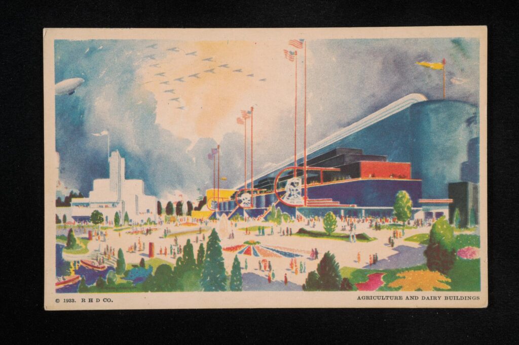 Impressionistic postcard of a large blue, red, white and yellow building with six American flags on top of it in front of large open space with flowers, trees, and people.