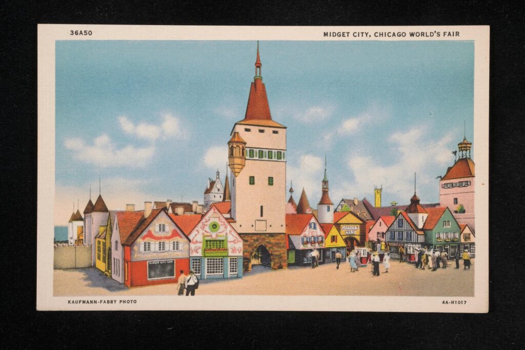 People walking in front of multicolored buildings with a large tan and red tower in the middle