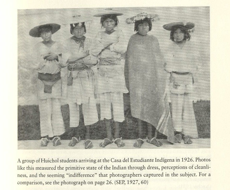 Black-and-white photo of five Huichol boys in traditional clothing. Below the image is the caption, "A group of Huichol students arriving at the Casa del Estudiante Indígena in 1926. Photos like this measured the primitive state of the Indian through dress, perceptions of cleanliness, and the seeming "indifference" that photographers captured in the subject. For a comparison, see the photograph on page 26. (SEP, 1927, 60).